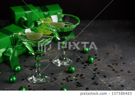 Green Cocktails with Lime,  Gifts and Confetti. Festive St. Patricks Day Celebration Still Life 137386483