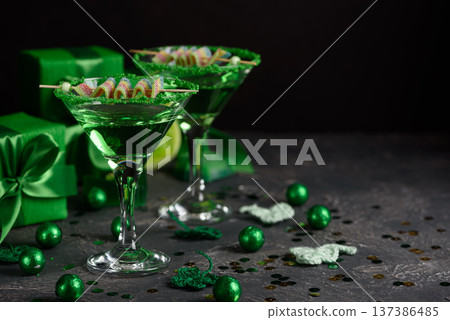 Green Cocktails with Rainbow Candy, shamrocks, Gifts and Confetti. Festive St. Patricks Day Celebration Still Life 137386485