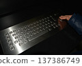 A close-up of a child's hands using an adaptive computer keyboard with large keys and a trackball. Concept: rehabilitation tools and educational support for children with disabilities. 137386749