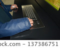 A close-up of a child's hands using an adaptive computer keyboard with large keys and a trackball. Concept: rehabilitation tools and educational support for children with disabilities. 137386751