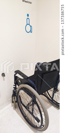 A wheelchair in a designated area for people with disabilities inside the building. The concept of inclusive infrastructure and support for people with disabilities. 137386755