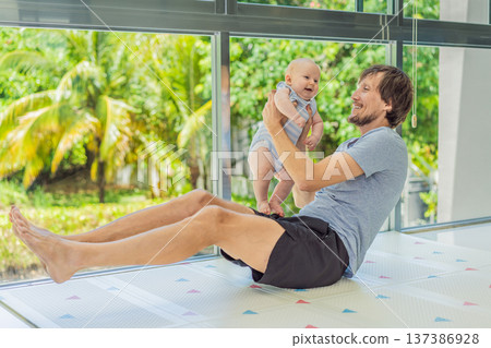 Father exercising with his small baby at home, active parenting and healthy lifestyle. Strong family bond, early physical development, modern fatherhood, fitness with children concept. Father exercising with his small baby at home, active parenting and healthy lifestyle. Strong family bond, early physical development, modern fatherhood, fitness with children concept. 137386928