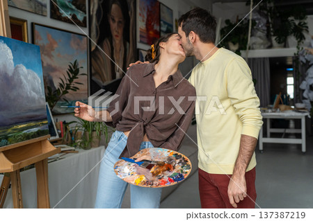 Happy married couple of artists sharing love and passion in relationships, gently kissing each other 137387219