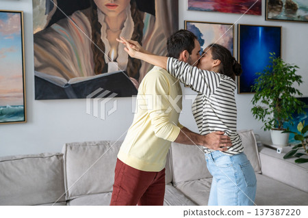 Passionate loving couple of artists embracing each other and kissing at home art gallery workshop. 137387220