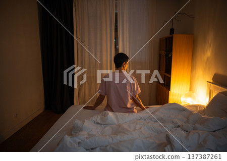 Sleepless pensive senior woman sitting in bed late at night coping with insomnia and overthinking. Sleepless pensive senior woman sitting in bed late at night coping with insomnia and overthinking. 137387261