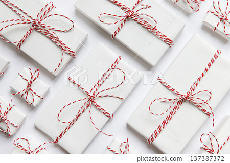 Flat lay composition with Christmas gifts boxes with red ribbon on white background. Flat lay composition with Christmas gifts boxes with red ribbon on white background. 137387372
