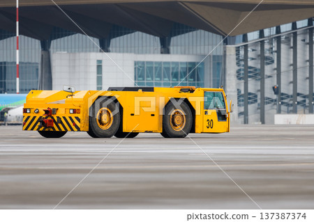 Airplane yellow pushback truck in moving at airport Airplane yellow pushback truck in moving at airport 137387374