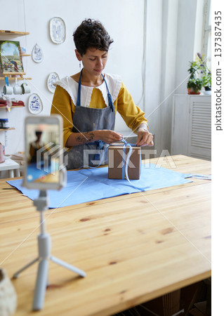 Artist vlogger make video packing handmade pottery, online master class of craft ceramics in studio Artist vlogger make video packing handmade pottery, online master class of craft ceramics in studio 137387435