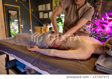 Woman receiving lover back body massage for better blood and lymphatic circulation in beauty clinic. 137387472