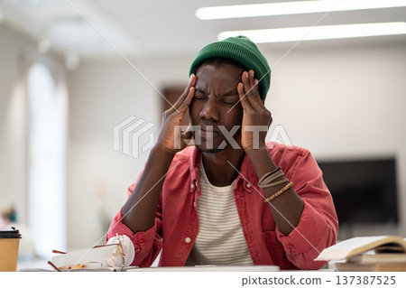 Exhausted black student man suffering from anxiety or panic attack after long prepare exam on laptop 137387525
