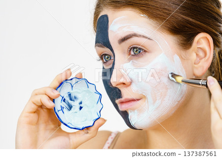 Girl black mask on half face apply white mud 137387561