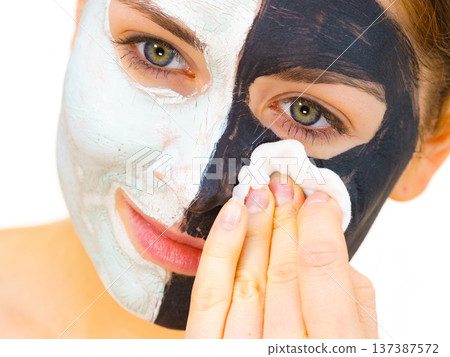 Girl remove black white mud mask from face 137387572