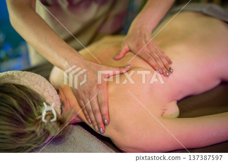 Professional lady masseuse making pain relief massage procedure on upper body for woman client. 137387597