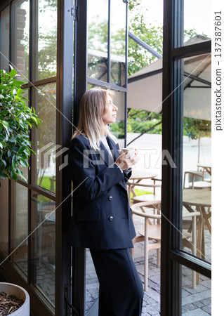 Relaxed pensive businesswoman small business owner drinking coffee and thinking about new goals. Relaxed pensive businesswoman small business owner drinking coffee and thinking about new goals. 137387601