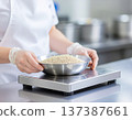 一名工人在午餐盒工廠用秤稱量穀物。 137387661