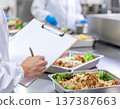 一名工人在便當工廠檢查生產線並填寫檢查清單。 137387663