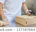 一名工人在便當工廠掃描紙盒上的條碼。 137387664