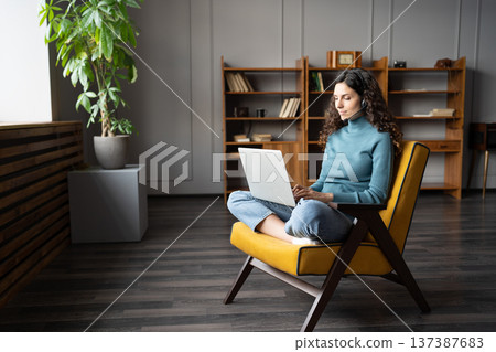 Young woman wearing headset studying online on laptop, Remote contact center agent working from home Young woman wearing headset studying online on laptop, Remote contact center agent working from home 137387683