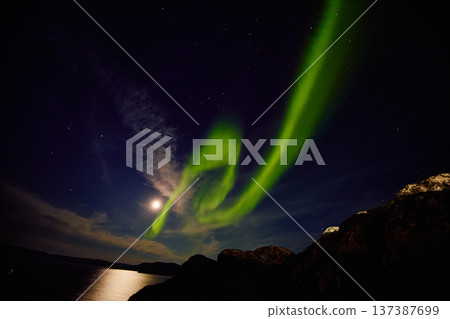 Aurora borealis over ocean in Teriberka, Russia, Murmansk region, Northern lights, Starry sky with polar lights and clouds. Night autumn landscape with bright aurora, stars, sea Aurora borealis over ocean in Teriberka, Russia, Murmansk region, Northern lights, Starry sky with polar lights and clouds. Night autumn landscape with bright aurora, stars, sea 137387699