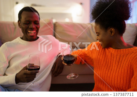 Loving black couple enjoy spending time together sit on floor at home relaxing with wine and talking 137387711