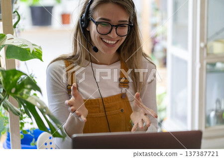 Gardener woman wear headphones talk in video chat, using laptop, communicating with clients 137387721