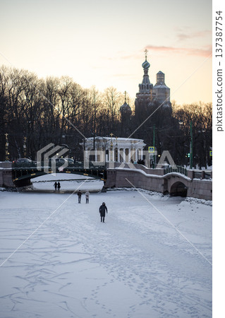 People walking along on frozen rivers and canals in St. Petersburg, Russia on cold winter day. People walking along on frozen rivers and canals in St. Petersburg, Russia on cold winter day. 137387754