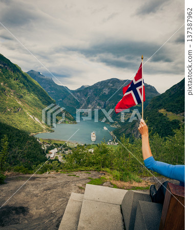 Tourist over Geirangerfjord holds norwegian flag 137387962