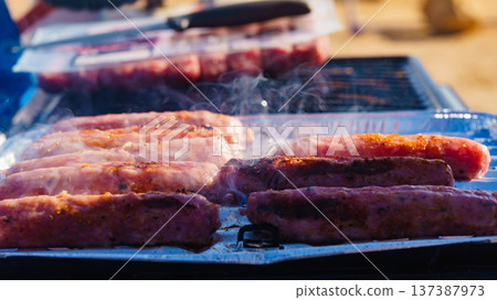 Sausages meat grilling on gas grill 137387973