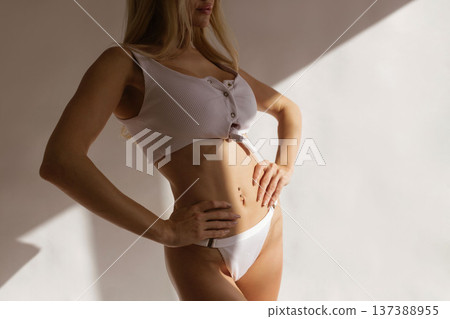 Slim sexy woman with toned body and flat stomach posing in white lingerie, fitness body care and beauty concept Slim sexy woman with toned body and flat stomach posing in white lingerie, fitness body care and beauty concept 137388955