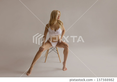 Beautiful woman with smooth legs sitting on chair after hair removal, skin care and epilation beauty concept Beautiful woman with smooth legs sitting on chair after hair removal, skin care and epilation beauty concept 137388982