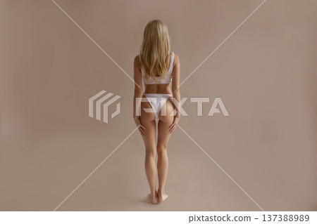 Attractive female body from back with toned hips and smooth skin in white lingerie, beauty and body care concept Attractive female body from back with toned hips and smooth skin in white lingerie, beauty and body care concept 137388989