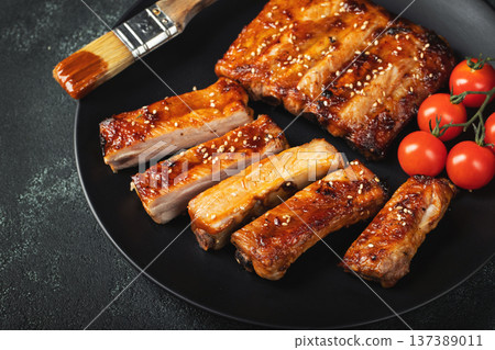 Hot grilled spare ribs from a summer BBQ served on a plate with sauce. Top view. Copy space Hot grilled spare ribs from a summer BBQ served on a plate with sauce. Top view. Copy space 137389011