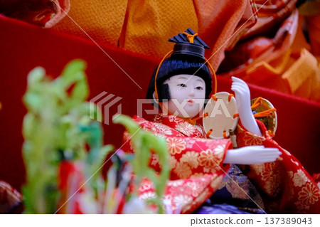 在鮮豔的紅色舞台上，一排排雛人偶整齊排列：展現了日本傳統的美麗。 137389043