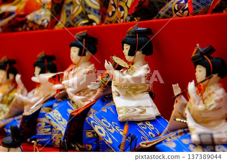 在鮮豔的紅色舞台上，一排排雛人偶整齊排列：展現了日本傳統的美麗。 137389044