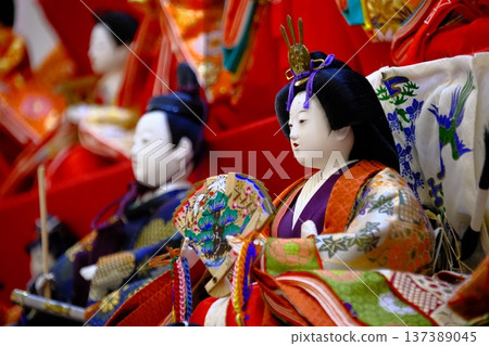 在鮮豔的紅色舞台上，一排排雛人偶整齊排列：展現了日本傳統的美麗。 137389045