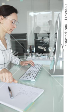 Woman analyst working on computer, analyzing business data with charts and graphs, marketing report on screen. Businesspeople concept Woman analyst working on computer, analyzing business data with charts and graphs, marketing report on screen. Businesspeople concept 137390025