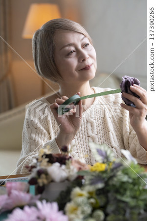老婦人在客廳製作插花作品 老婦人在客廳製作插花作品 137390266