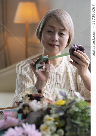老婦人在客廳製作插花作品 老婦人在客廳製作插花作品 137390267
