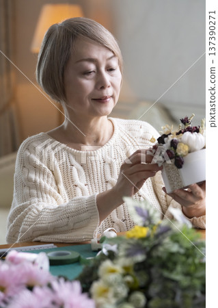 老婦人在客廳製作插花作品 老婦人在客廳製作插花作品 137390271