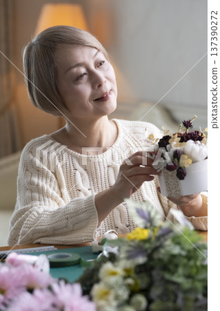 老婦人在客廳製作插花作品 老婦人在客廳製作插花作品 137390272