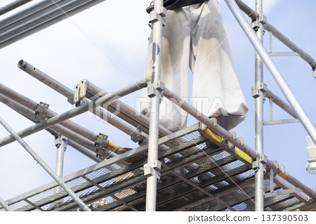 Workers assembling scaffolding 137390503