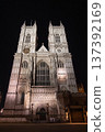 Westminster Abbey, London. The Gothic architecture is beautifully illuminated under the evening sky, showcasing the detailed facade and majestic towers. 137392169