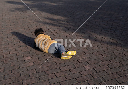 A child lying on the ground throwing a tantrum A child lying on the ground throwing a tantrum 137393282