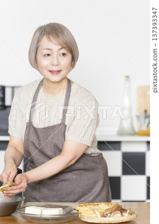 老婦人在廚房切菜備餐 老婦人在廚房切菜備餐 137393347