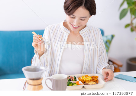 餐點:一位女士正在吃外帶午餐 餐點:一位女士正在吃外帶午餐 137393877