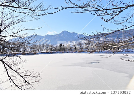 The frozen surface of Jitaike Pond and early spring scenery of Mount Kanmuri The frozen surface of Jitaike Pond and early spring scenery of Mount Kanmuri 137393922