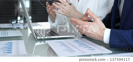 Group of business professionals collaborating during a corporate meeting in a modern office, analyzing financial charts. Concept of teamwork, finance, success, and professional cooperation Group of business professionals collaborating during a corporate meeting in a modern office, analyzing financial charts. Concept of teamwork, finance, success, and professional cooperation 137394117