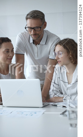 Business people team collaborating and analyzing data on a laptop during an office meeting, uniting efforts to reach shared objectives and drive successful outcomes together Business people team collaborating and analyzing data on a laptop during an office meeting, uniting efforts to reach shared objectives and drive successful outcomes together 137394124