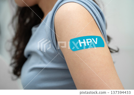 HPV, Human papillomavirus, Asian young woman receiving vaccine with blue bandage. HPV, Human papillomavirus, Asian young woman receiving vaccine with blue bandage. 137394433
