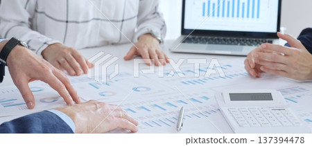 Business professionals analyzing financial data using charts, graphs, and reports during an office meeting, collaborating on strategy and economic growth Business professionals analyzing financial data using charts, graphs, and reports during an office meeting, collaborating on strategy and economic growth 137394478